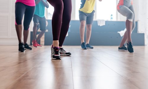 Cropped view of multicultural dancers exercising movements of zumba in dance studio