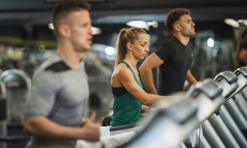 Shot of three young people exercising on a treadmill at the gym.